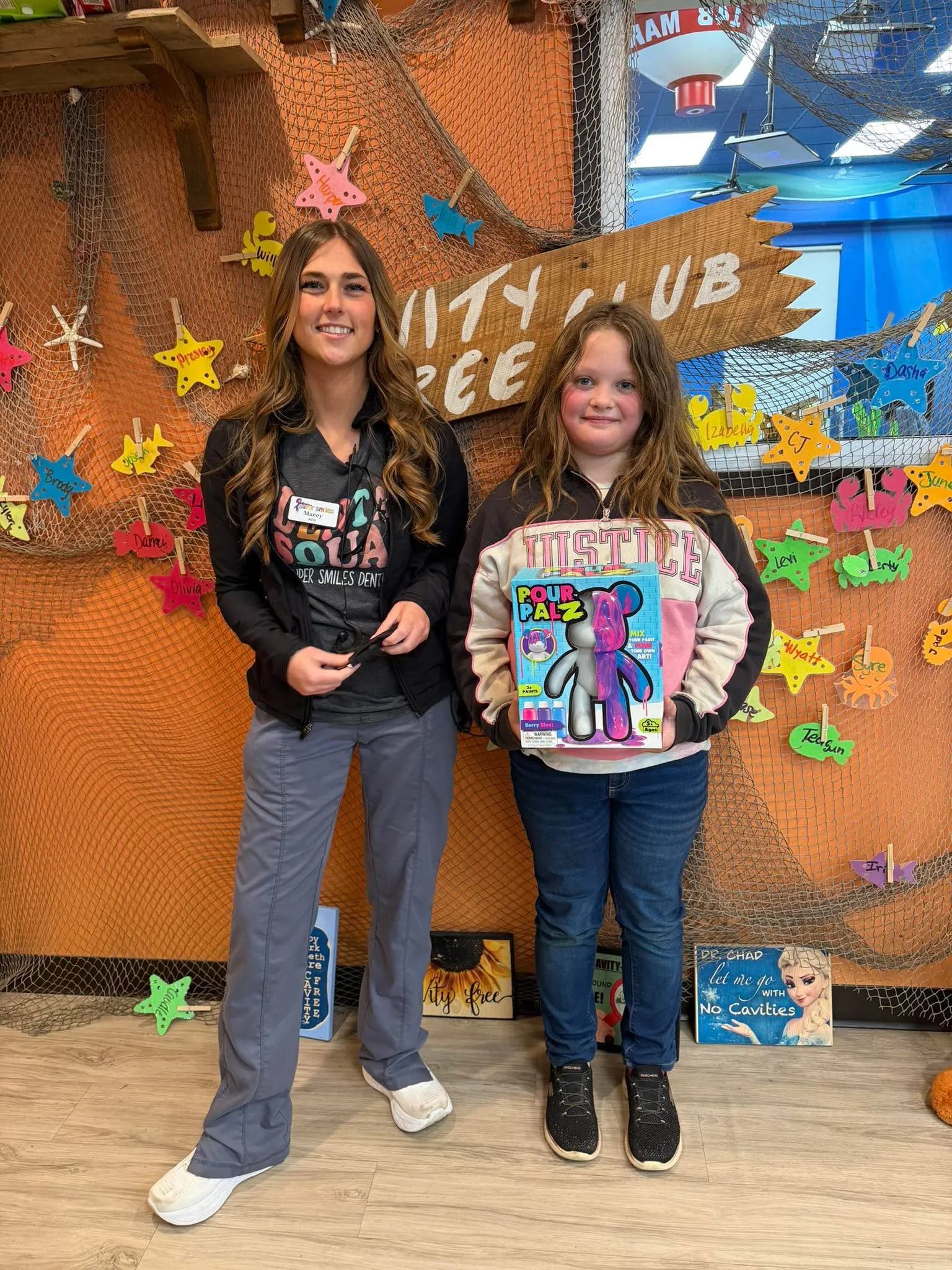 A Cavity Free Club winner posing in front of the full club wall